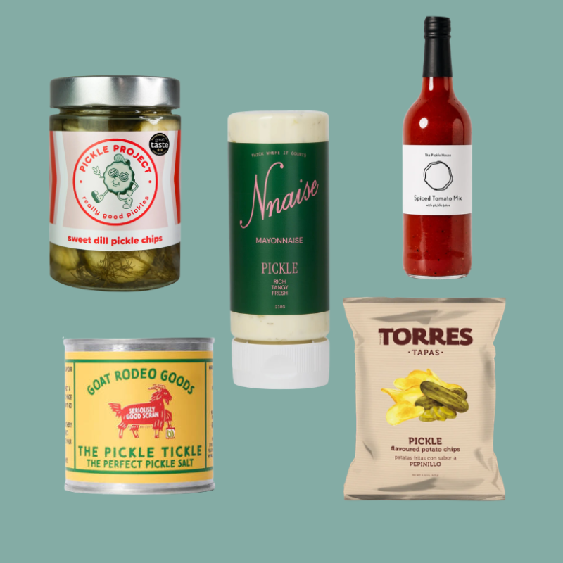 A collage of five gourmet pickle and food products on a solid teal background: a jar of Pickle Producers sweet cill pickle chips, a squeeze bottle of Nmaisé Pickle Mayonnaise, a bottle of Torres Tapa's Spiced Tomato Pickle, a tin of Goat Rodeo Goods The Pickle Tickle salt, and a bag of Torres Tapa's Pickle Infused Chips.