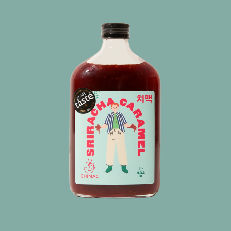 A bottle of CHIMAC Sriracha Caramel sauce with a black cap, set against a solid teal-green background. The label features a light blue background with a cartoon illustration of a person and bold red text.