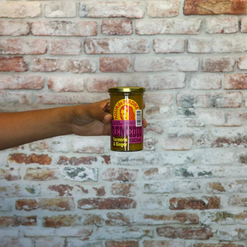 Hand holding a can against a brick wall