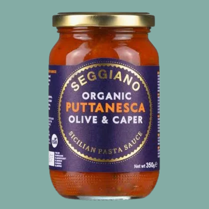 Jar of Seggiano Organic Puttanesca Olive & Caper Pasta Sauce on a green background