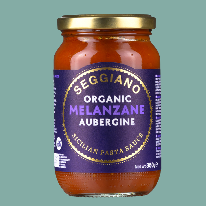 Jar of Seggiano Organic Melanzane Aubergine pasta sauce on a green background