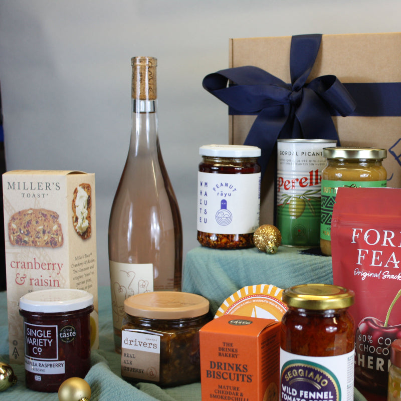 Assorted food and drink products including bottles, jars, and a box on a table.