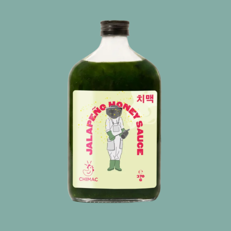 A bottle of Chimac Jalapeño Honey Sauce with a light green label and dark green sauce inside, set against a solid teal background.