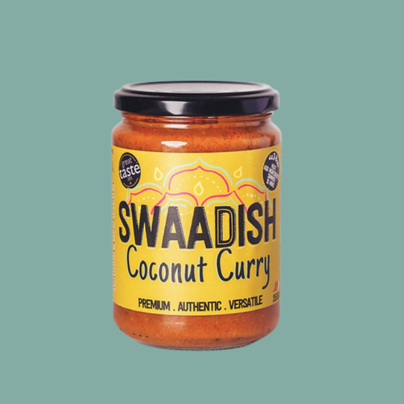 A glass jar of Swaadish Coconut Curry with a black lid and a bright yellow label, centered against a solid teal-green background.