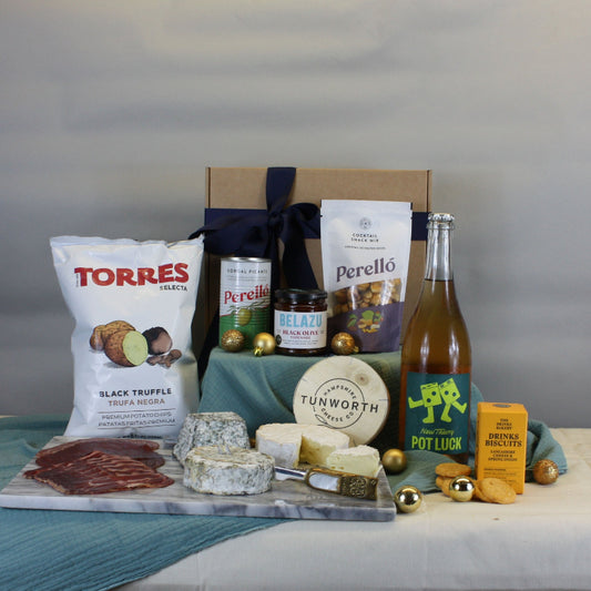Table with food products including a bottle, cheese, and a box against a plain background