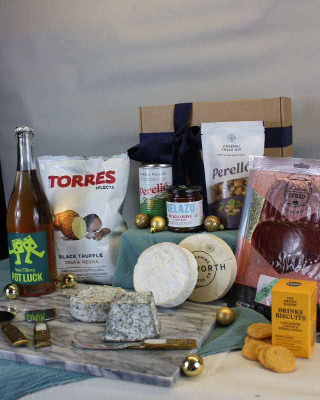 Assorted food items including cheeses, a bottle, and packaging on a table.