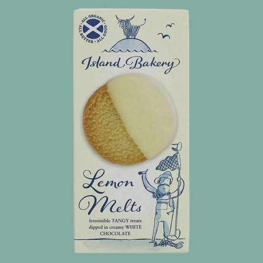 A package of Island Bakery Lemon Melts, featuring a round cookie half-dipped in creamy white chocolate, set against a solid sage green background.
