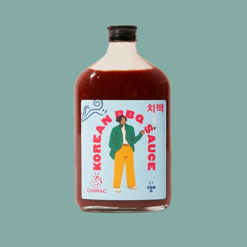 A bottle of Chimac Korean BBQ Sauce with a black cap, filled with dark reddish-brown sauce, featuring a colorful illustrated label on a solid teal background.