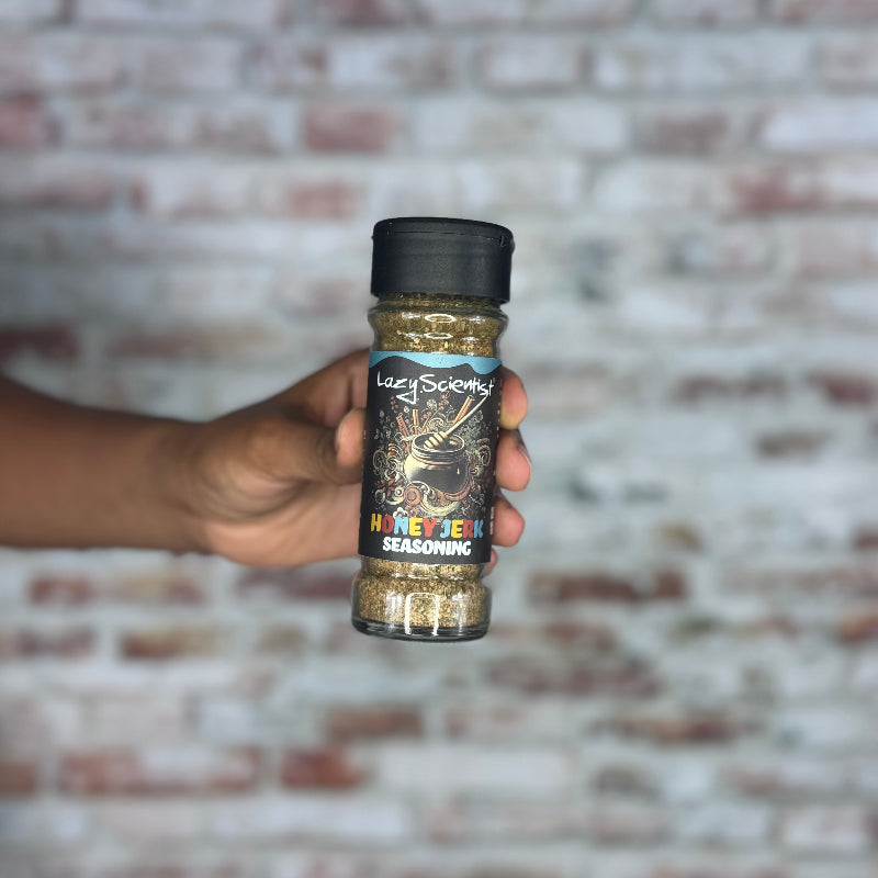 Hand holding a seasoning bottle against a brick wall background