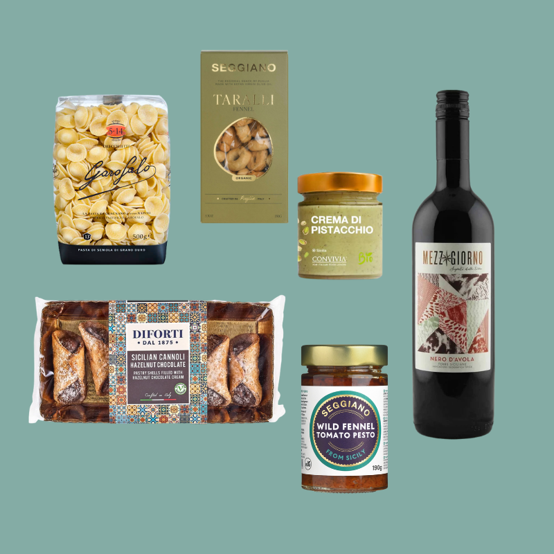 A curated assortment of gourmet Italian products arranged on a solid teal-green background, including pasta, crackers, a jar of crema, a bottle of wine, and packaged meats. Visible brands include Secchio, Diforti, and Mezzogiorno.