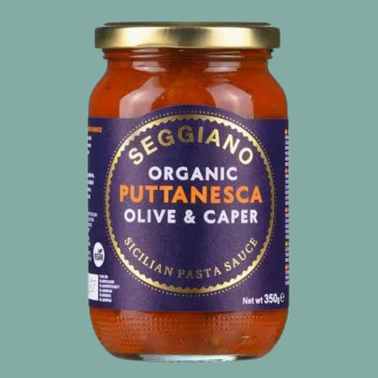 Jar of Seggiano Organic Puttanesca Olive & Caper Pasta Sauce on a green background