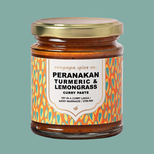 Jar of Peranakan Turmeric & Lemongrass Curry Paste with a colorful label on a teal background