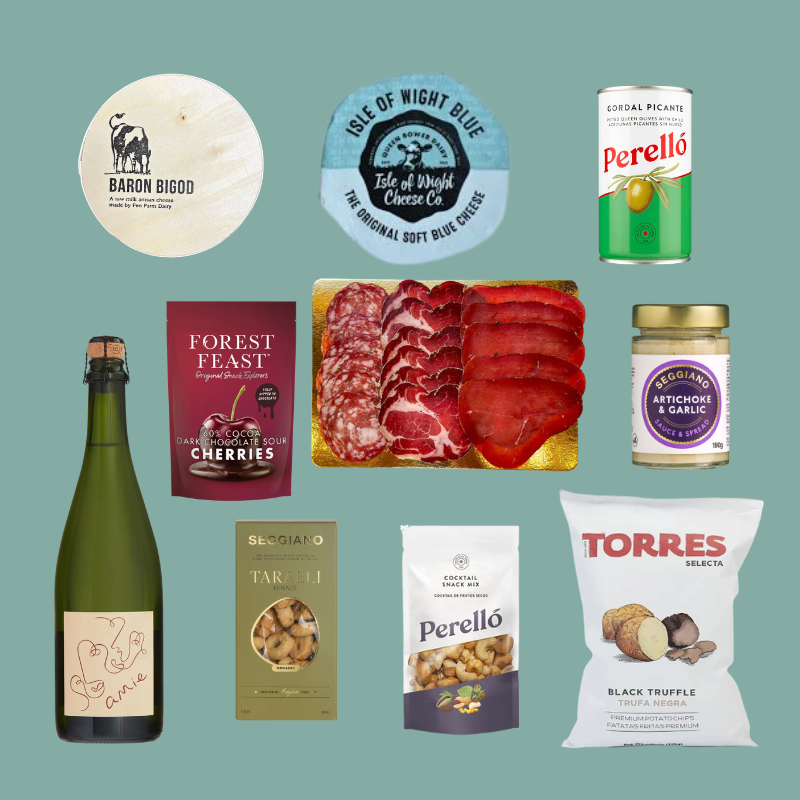 A flat lay collage of multiple retail food and beverage products on a muted green background, including Baron Bigod cheese, Isle of Night Blue blue cheese, Perello salami and canned olive oil, Forest Feast cherries, a bottle of Prosecco, Seigiaoio taralli, Perello artisanal cheese, and Torres black truffle chips.