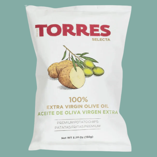 A white bag of Torres Selecta 100% extra virgin olive oil potato chips, featuring illustrations of potatoes and olives on a solid teal background.